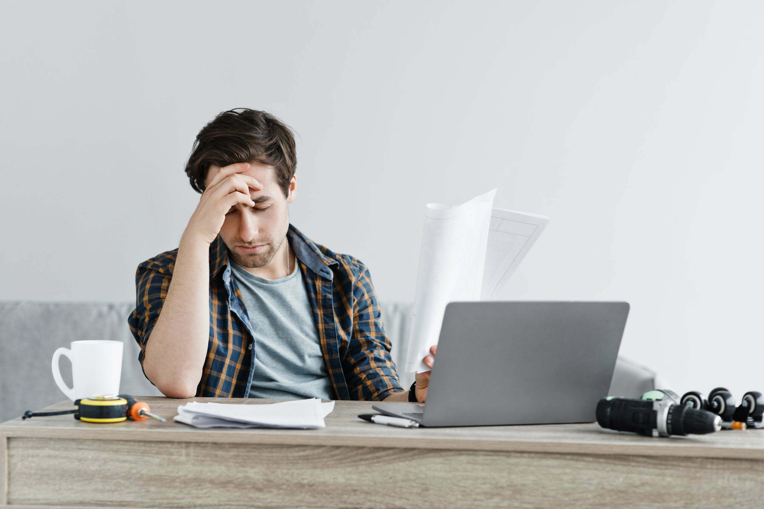 a person sitting at a desk with a laptop and headphones